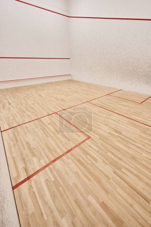 moderner Squash-Gerichtssaal mit weißen Wänden und poliertem Boden, Motivations- und Zielstrebigkeitskonzept