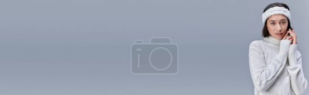 Téléchargez les photos : Élégant asiatique femme avec des cheveux enneigés et bandeau regardant caméra sur gris, hiver mode, bannière - en image libre de droit