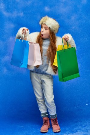 compras de vacaciones, chica impactada en chaqueta de piel sintética con bolsas de compras en el telón de fondo turquesa