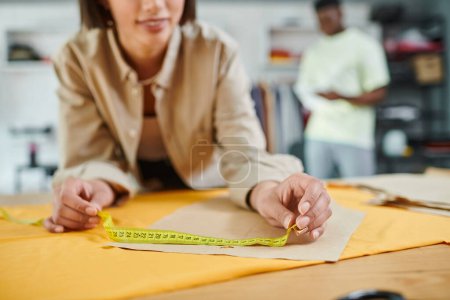 cropped view of creative designer measuring sewing pattern in print studio, small business