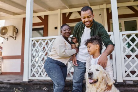 Foto de Foto de familia, padres afroamericanos felices e hijo jugando con el perro en el patio trasero de su casa - Imagen libre de derechos
