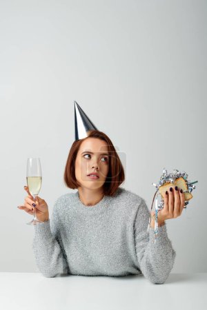 young woman in party cap holding champagne glass and sandwich with tinsel, Merry Christmas concept