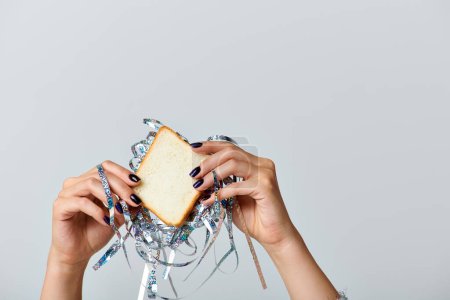 vue partielle de femme tenant sandwich avec moule sur fond gris, concept Bonne année