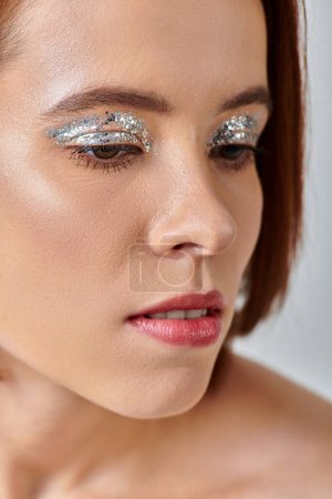 close up view of attractive young woman with holiday makeup, shimmery eye shadow and closed eyes
