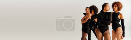 four appealing african american women in black alluring attire posing together, fashion, banner