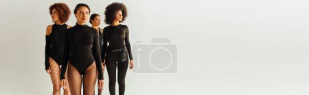 attractive young african american female friends in black appealing bodysuits, fashion, banner