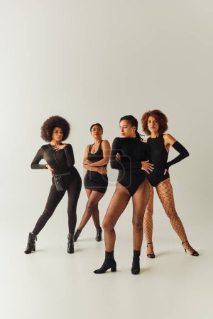 attractive young african american female friends in black appealing bodysuits, fashion concept