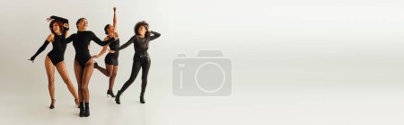 Téléchargez les photos : Joyeux afro-américains amies en costumes sexy dansant joyeusement, concept de mode, bannière - en image libre de droit