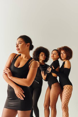 Photo for Appealing sexy african american women in black stylish bodysuits posing together, fashion concept - Royalty Free Image
