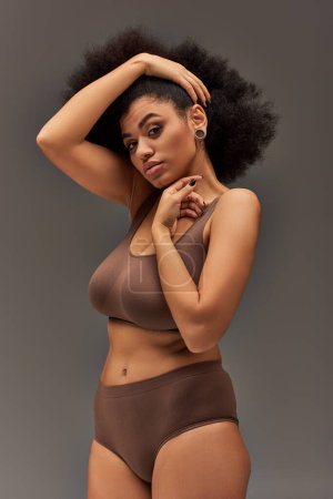 young african american woman in pastel underwear with black nail polish posing alluringly, fashion