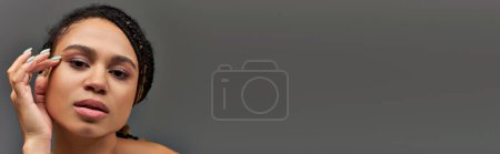 Téléchargez les photos : Jeune belle femme afro-américaine en sous-vêtements pastel beige posant sérieusement, mode, bannière - en image libre de droit