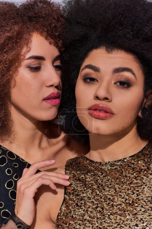 portrait of beautiful african american women posing together and looking at camera, fashion concept