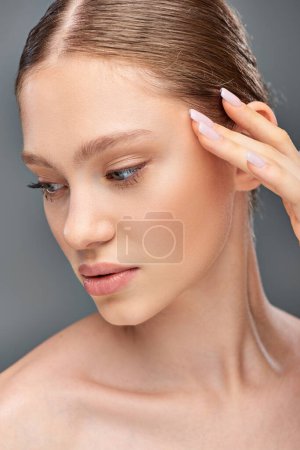 Photo for Portrait of beautiful young woman with perfect skin posing with hand near face on grey background - Royalty Free Image