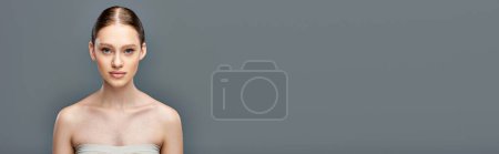 kein Make-up-Banner, schöne junge Frau mit nackten Schultern, die in die Kamera auf grauem Hintergrund blickt