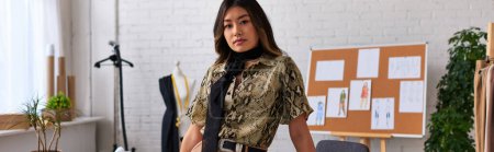 Téléchargez les photos : Confiant styliste asiatique à la mode regardant la caméra dans l'atelier de vêtements privés, bannière horizontale - en image libre de droit