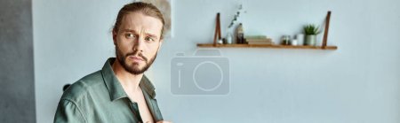 portrait of thoughtful and bearded adult man looking away in bedroom at home, horizontal banner