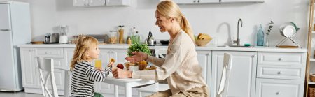 niña desayunando con la madre rubia feliz en la cocina moderna, banner de la vida diaria