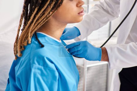 Téléchargez les photos : Médecin indien écoute souffle de son patient afro-américain malade avec stéthoscope, recadré - en image libre de droit