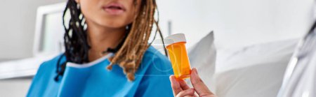 Téléchargez les photos : Femme afro-américaine malade regardant son médecin indien lui donner des pilules dans la salle d'hôpital, bannière - en image libre de droit