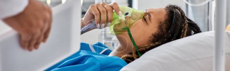 Téléchargez les photos : Vue recadrée du médecin réconfortant femme afro-américaine malade couchée au lit avec masque à oxygène, bannière - en image libre de droit