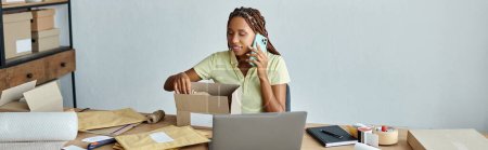 heureuse vendeuse afro-américaine parlant par téléphone et boîte d'emballage, concept de livraison, bannière