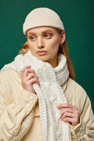 Téléchargez les photos : Femme chère en veste chaude et écharpe blanche avec bonnet chapeau sur fond vert, mode d'hiver - en image libre de droit