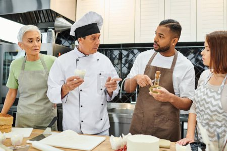 handsome african american man holding oil talking to mature chef next to friends, cooking courses