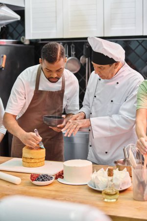 mature chef in white hat teaching his african american student how to use silicone brush on cake