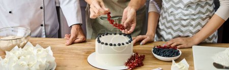 Téléchargez les photos : Vue recadrée de femme mature décoration gâteau avec groseille rouge près du chef et son jeune ami, bannière - en image libre de droit