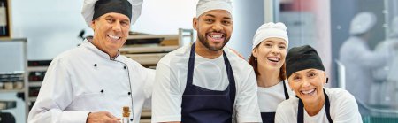 chefs alegres y diversos jefe de cocina sonriendo a la cámara mientras se trabaja con masa, confitería, pancarta