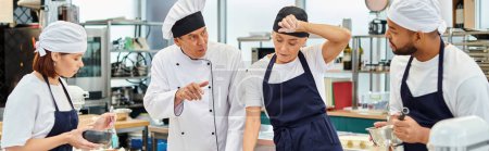Photo for Mature chief cook in white hat explaining how to bake to his multiracial hard working chefs, banner - Royalty Free Image