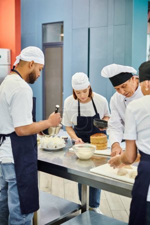 Multikulturelles Team von Köchen in Schürzen und Hauben, die gemeinsam mit dem Chefkoch am Gebäck arbeiten