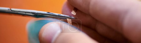 Téléchargez les photos : Vue partielle du fil de coupe de technicien expérimenté de dispositif électronique dans l'atelier de réparation, bannière - en image libre de droit