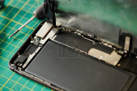 téléphone portable cassé et tournevis sur la table dans l'atelier de réparation, concept d'entreprise de réparation électronique
