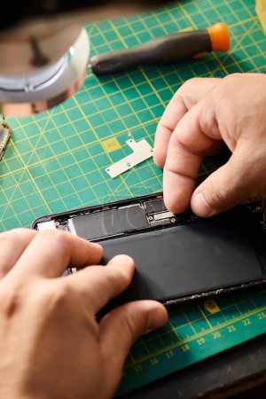 Photo for Partial view of technician assembling mobile phone after reparation in workshop, small business - Royalty Free Image