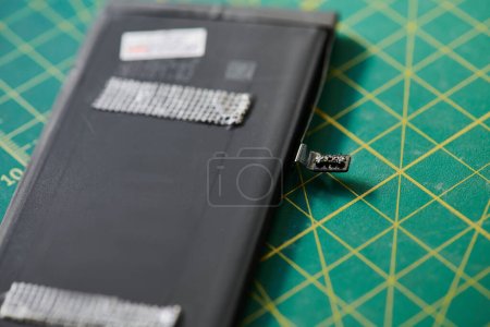 vue rapprochée de la batterie de téléphone portable sur la table dans l'atelier de réparation, entreprise de maintenance électronique