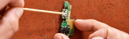 Téléchargez les photos : Vue recadrée du chipset électronique de nettoyage de technicien expérimenté dans l'atelier privé, bannière - en image libre de droit