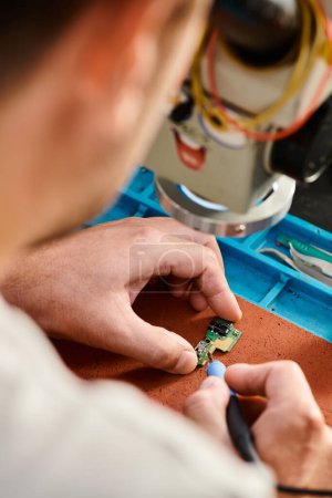 Téléchargez les photos : Vue recadrée du chipset de soudure de technicien professionnel dans l'atelier de réparation, service d'entretien - en image libre de droit