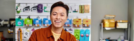 happy successful asian businessman looking at camera in private electronics store, horizontal banner