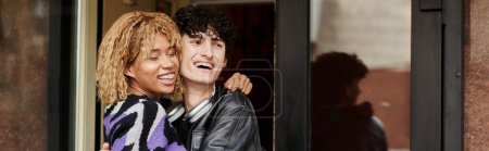 Foto de Feliz pareja diversa en ropa casual abrazándose a la entrada de la cafetería vegana, banner de fecha de café - Imagen libre de derechos