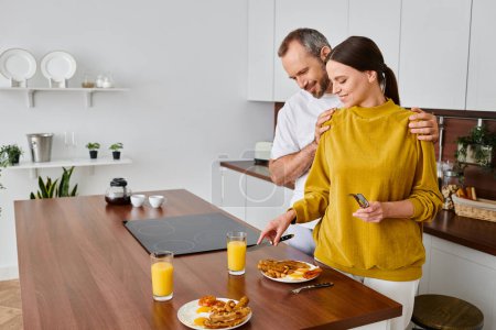 glücklicher Mann umarmt Schultern seiner Frau, die leckeres Frühstück in der Küche serviert, am Morgen des kinderfreien Paares