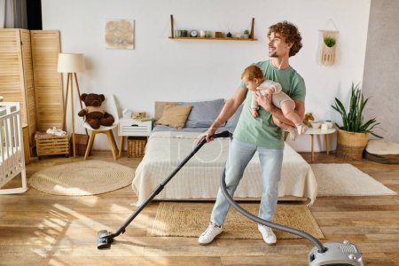 glücklicher Mann Multitasking-Hausarbeit und Kinderbetreuung, Vater staubsaugt Schlafzimmer mit Säugling im Arm
