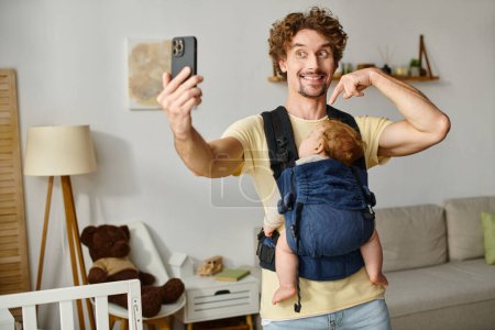 joyful father taking selfie with sleeping baby in carrier, fatherhood and modern parenting concept