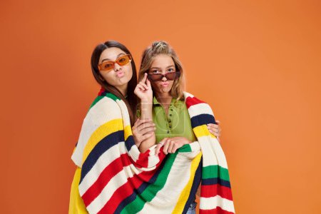 cheerful pretty teenage girls with sunglasses posing with pouted lips and looking at camera