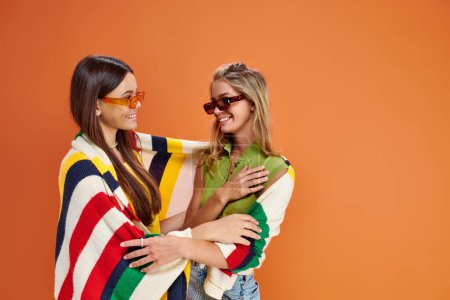 Téléchargez les photos : Joyeux jolies adolescentes avec des lunettes de soleil étreignant et se regardant, jour de l'amitié - en image libre de droit