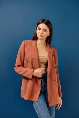 chica adolescente de moda en elegante chaqueta marrón con el pelo largo posando y mirando a la cámara