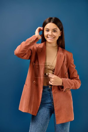 cheerful elegant teenage girl in fashionable brown blazer posing and smiling happily at camera