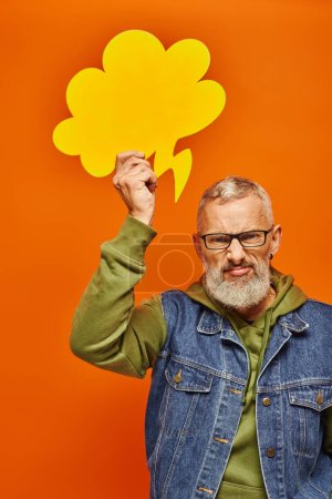 Photo for Angry mature man in vibrant green hoodie posing with thought bubble above head and looking at camera - Royalty Free Image