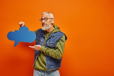 Photo for Funky good looking mature male model in stylish outfit holding thought bubble and looking at camera - Royalty Free Image