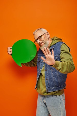 good looking mature male model with glasses holding speech bubble and showing stop sign with palm